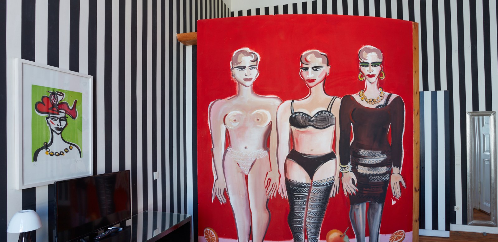 schwarz weiß gestreiftes Hotelzimmer mit drei Damen in rot Kunstwerk