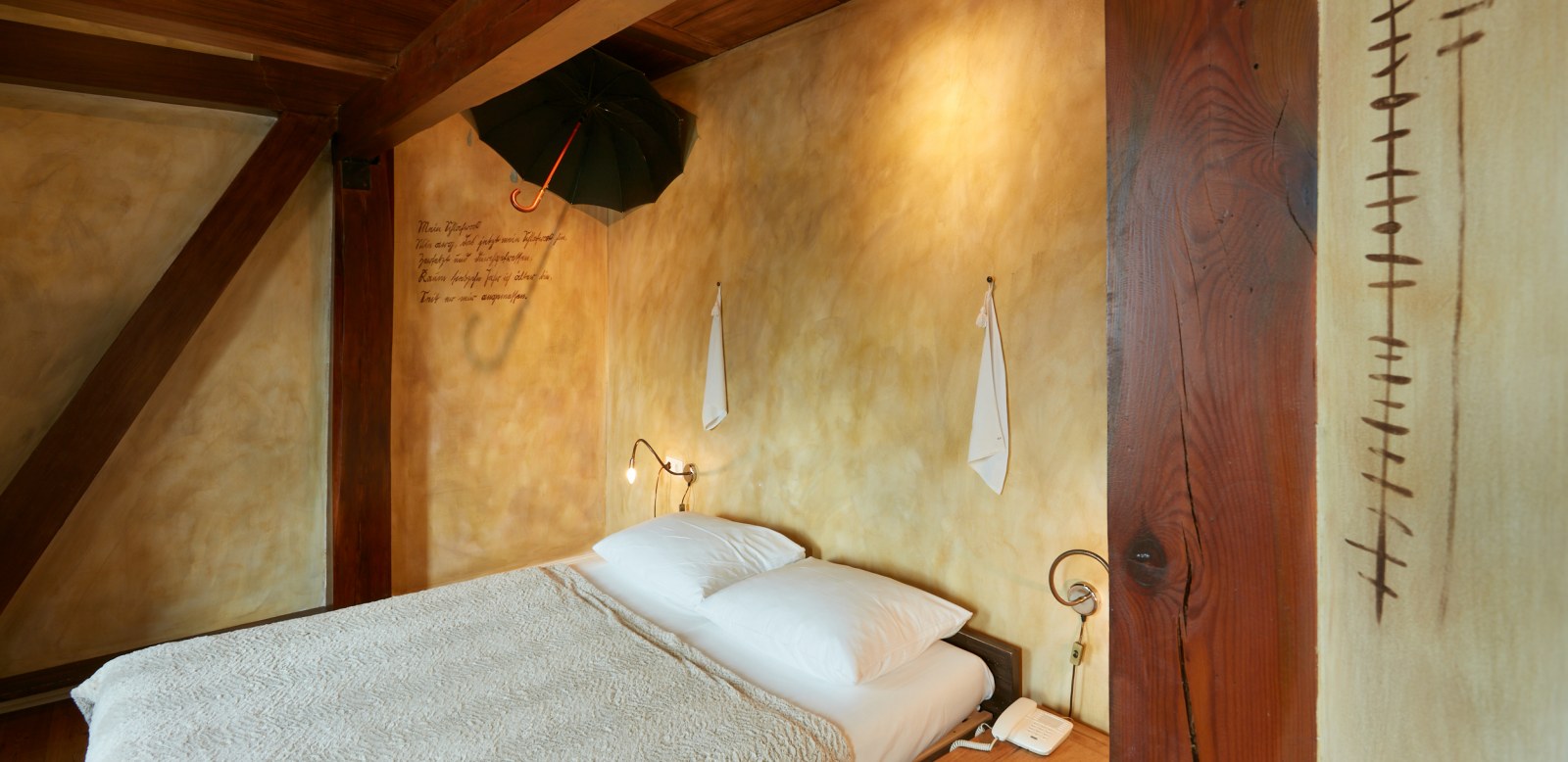 Double bed in bright room with yellow walls and wooden paneling
