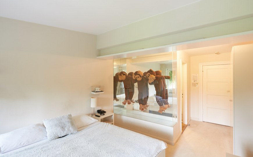 Ein künstlerisches Hotelzimmer mit drei Affen an der Wand.