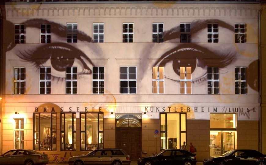 Das Arte Luise Kunsthotel besonders beleuchtet bei Nacht mit dem Gesicht einer Frau