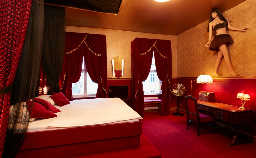 Ein besonderes Hotelzimmer im Stil der 1920er Jahre mit rotem Samt und Brokat.