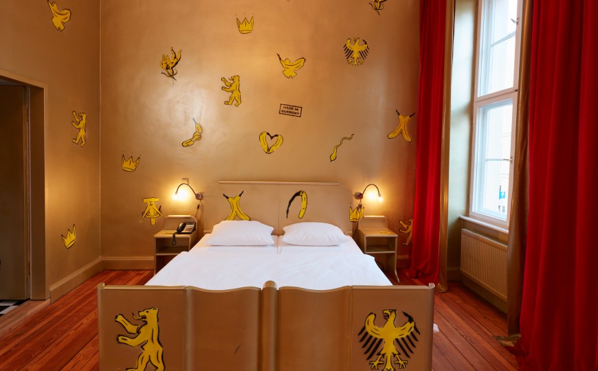 Ein besonderes Hotelzimmer mit gemalten Bananen an der Decke und an den Möbeln.