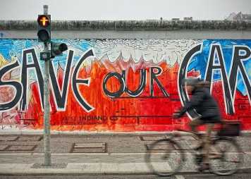 Mann auf dem Fahrrad in Berlin an der East Side Gallery